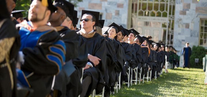 Photo of graduated sitting in chairs at commencement
