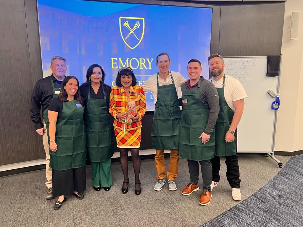 Our team selected Starbucks for our final project—and leaned into a “C-suite not afraid to roll up our sleeves” vibe (green aprons included). L-R: Jeff Henness 27EMBA, Christine Turquie 27EMBA, Urmila Murthy 27EMBA, Professor Usha Rackliffe, Alan Ligon 27EMBA, Jordon Jones 27EMBA, Mike Schoppmann 26EMBA