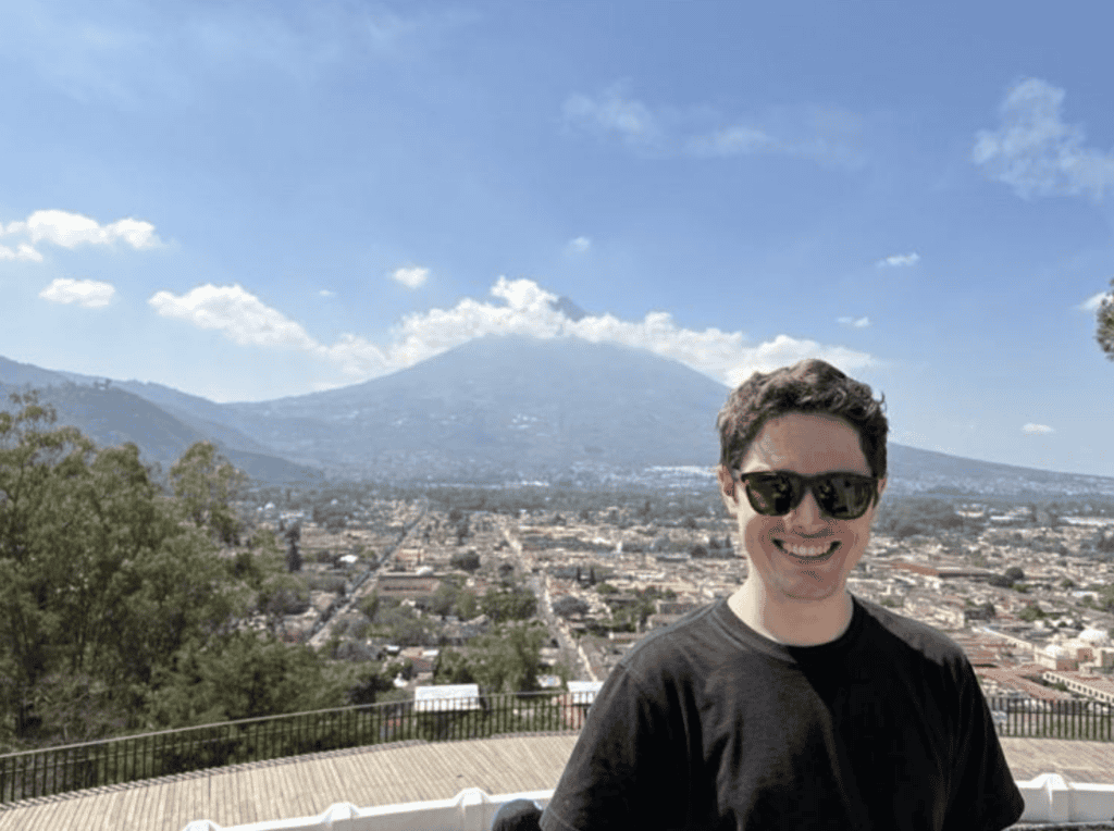 Michael Coyne 26MBA above Antigua on Cerro de la Cruz with the town and volcano in the background