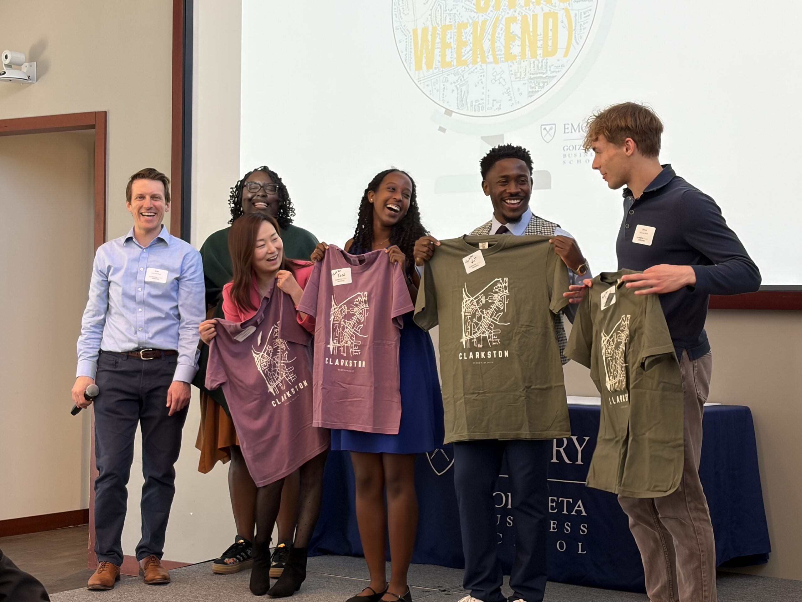 Co-instructors Brian Goebel and Tene Traylor presenting the student leadership team with Clarkston t-shirts.