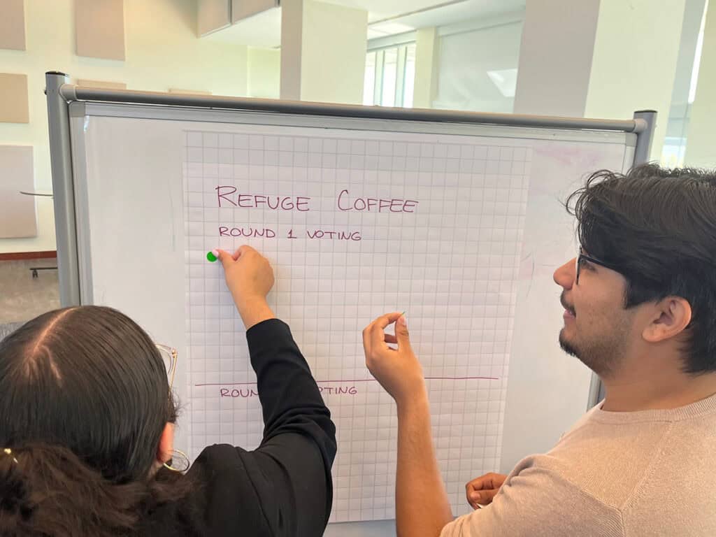 Students using dot voting to determine final funding allocations.